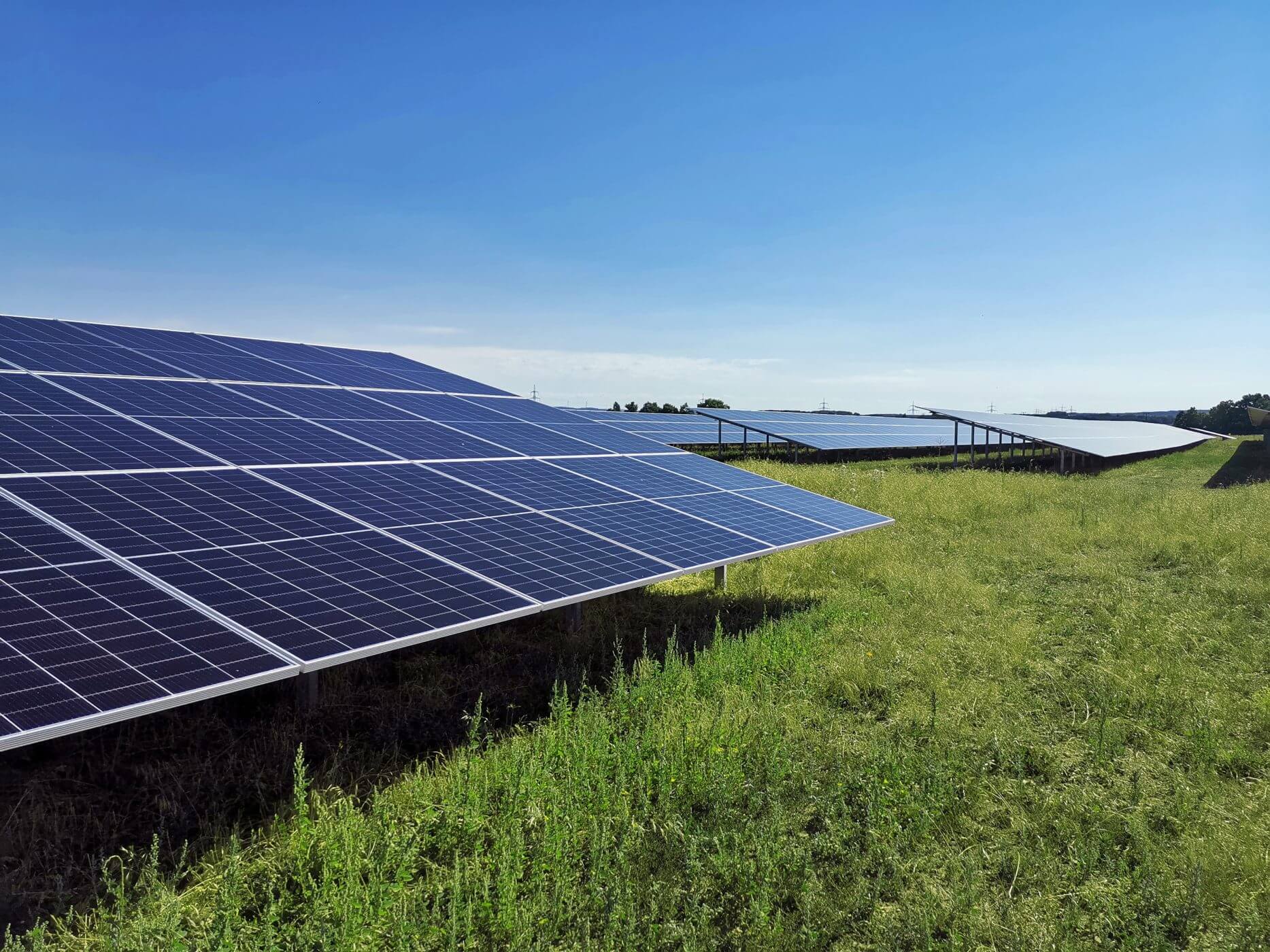 Ein Solarpark in Franken bei blauem Himmel und Sonnenschien