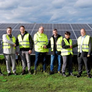 Employees of BELECTRIC and Low Carbon perform handshakes on a solar power plant