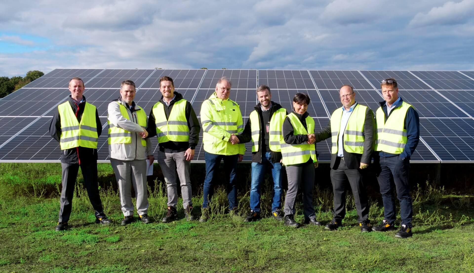 Employees of BELECTRIC and Low Carbon perform handshakes on a solar power plant