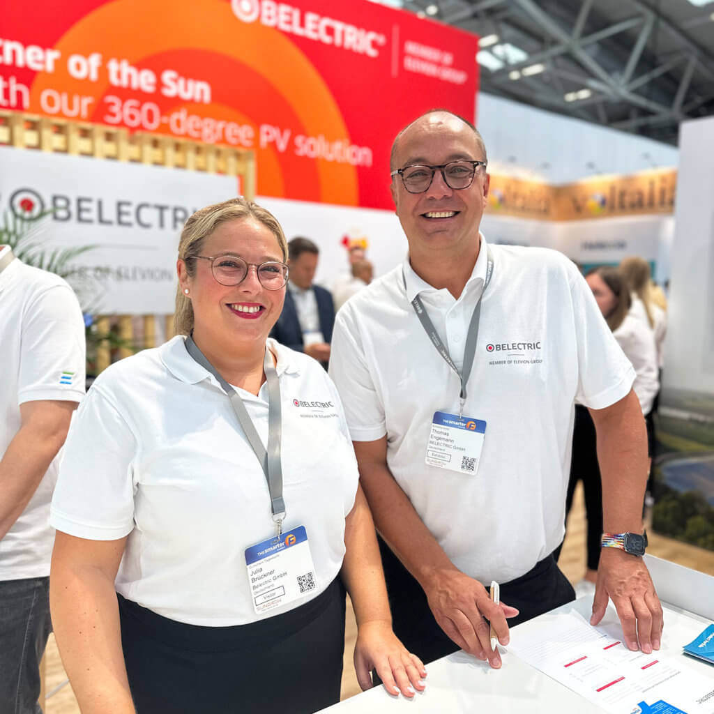 Two BELECTRIC employees stand on the company's booth for a trade fair for solar energy