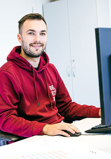 A BELECTRIC employee working in Procurement sits in front of a computer