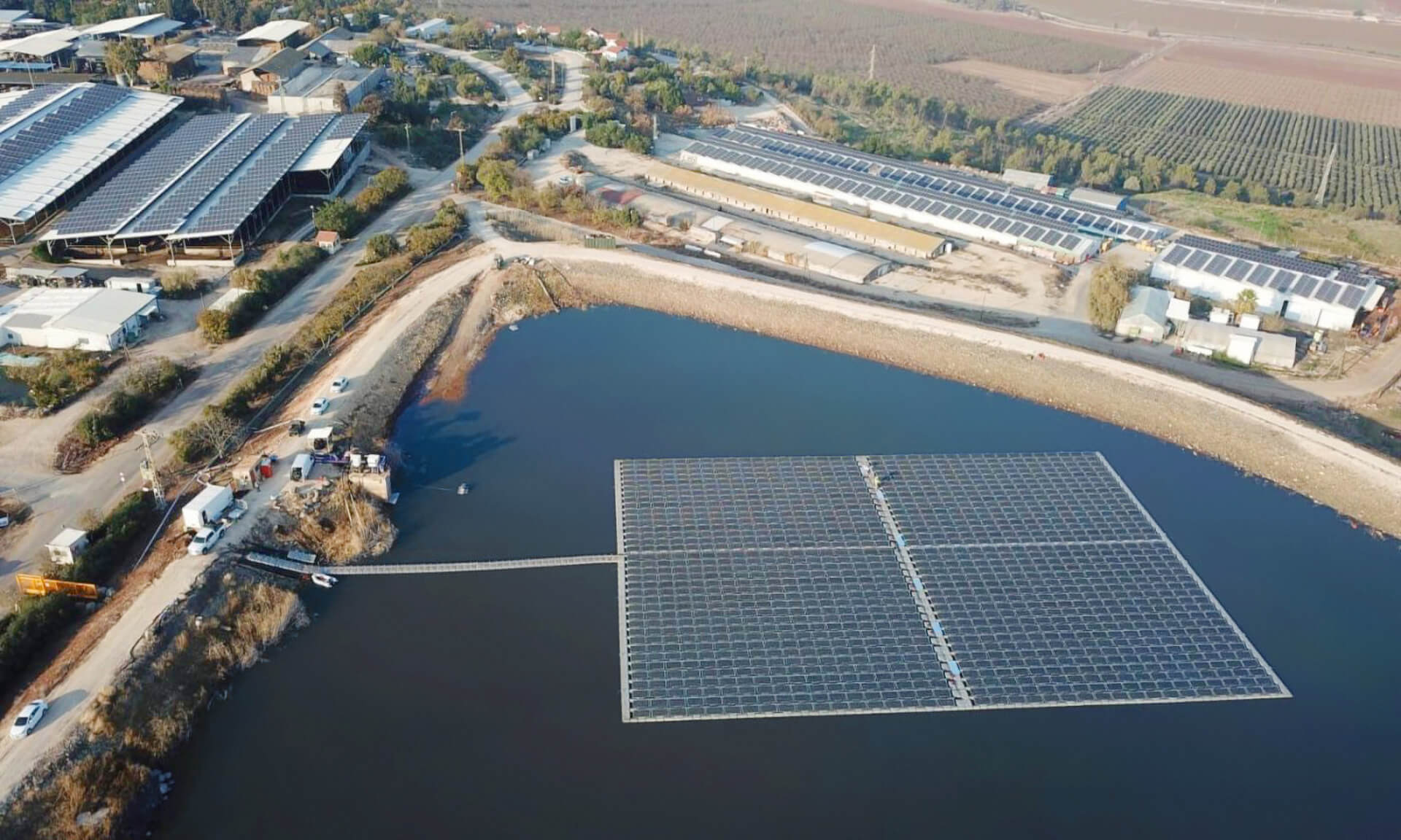 floating solar power plant on the water with buildings in the background