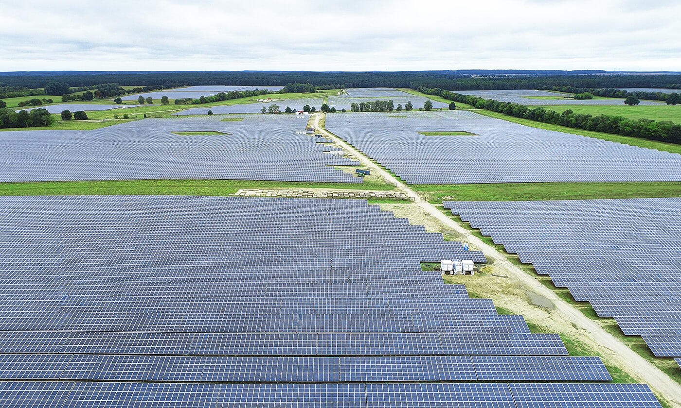 solar power plant with green fields and trees seen from above