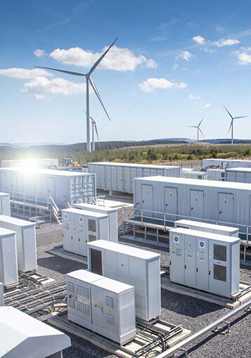 A battery storage system in front of a wind farm