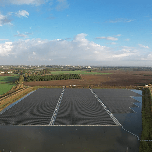 floating solar farm on the water constructed by BELECTRIC Israel with fields and trees in the back