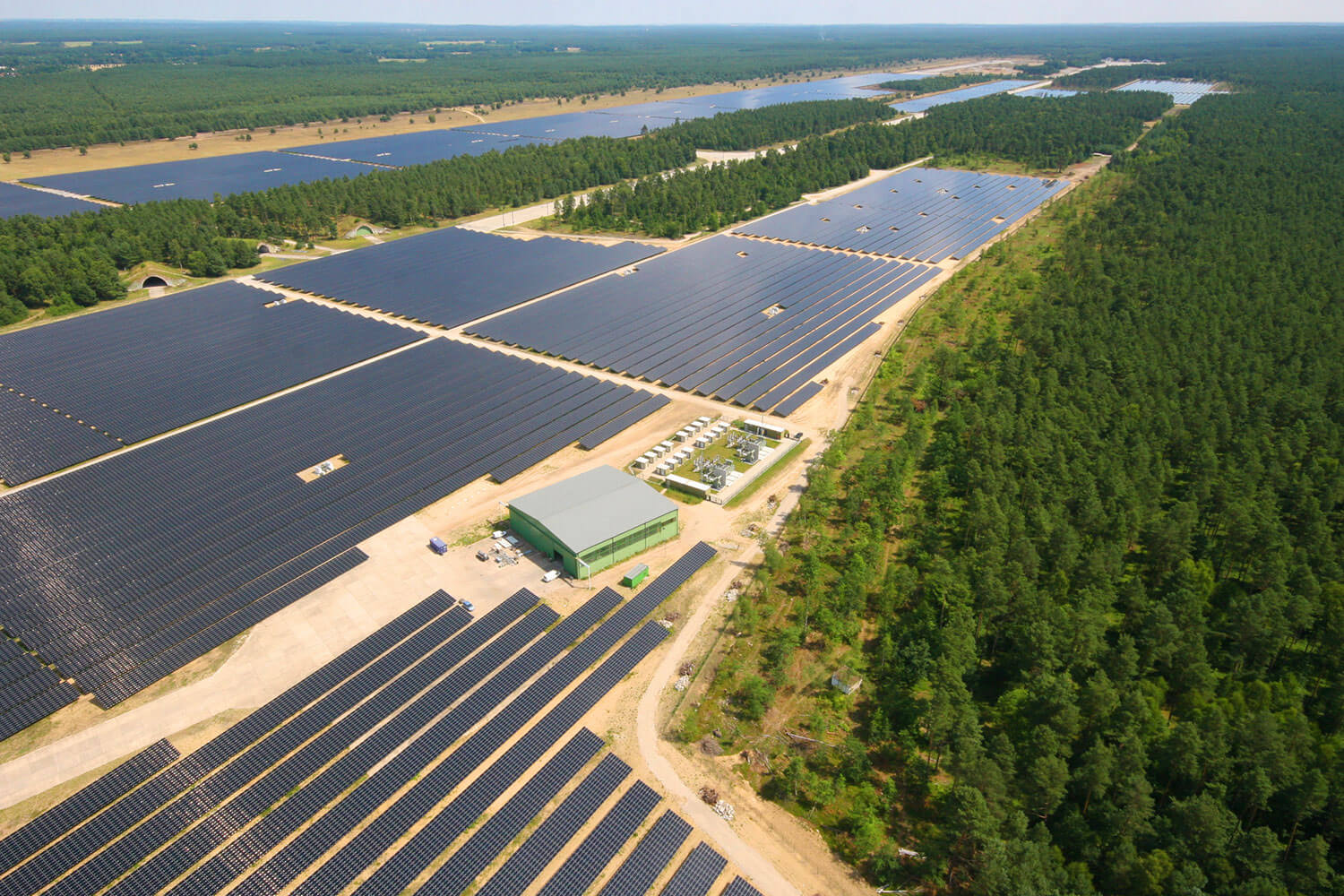 Der großflächige BELECTRIC-Solarpark in Templin, Deutschland, von oben in Mitten eines Waldes
