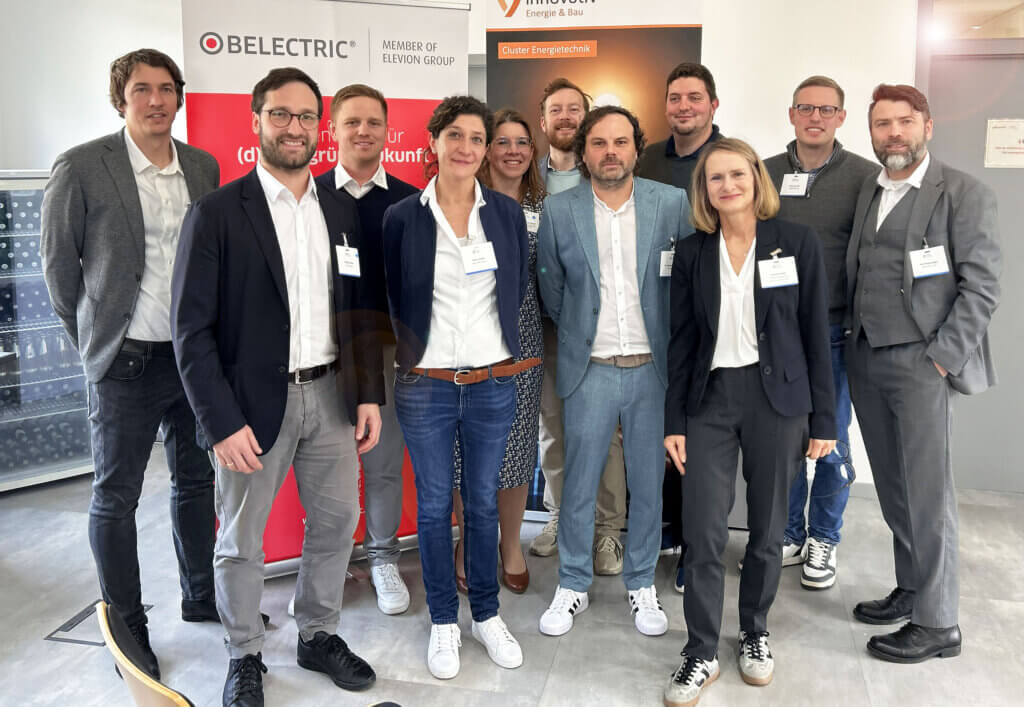 Bei BELECTRIC fand ein Cluster-Treff zum Thema Batteriespeicher statt. Auf dem Bild stehen einige der Teilnehmerinnen und Teilnehmer für ein Gruppenfoto zusammen und lächeln in die Kamera.