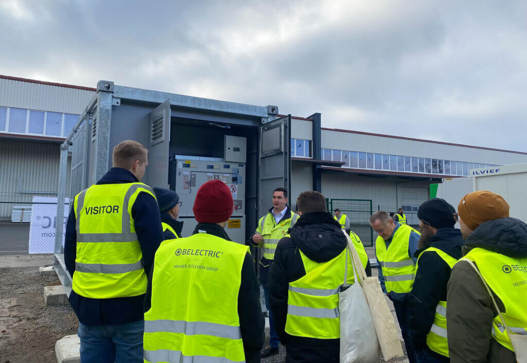 Während des BELECTRIC-Cluster-Treffs zum Thema Batteriespeicher besuchten die Teilnehmerinnen und Teilnehmer eines der Speicherprojekte von BELECTRIC. Auf dem Foto stehen sie vor einem Batteriespeicher-Container.