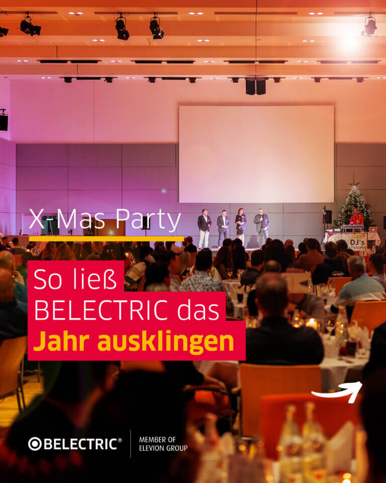 Die BELECTRIC-Geschäftsführung steht auf einer Bühne, davor sitzen dutzende Mitarbeitende. Darauf steht der Text "X-Mas Party: So ließ BELECTRIC das Jahr ausklingen"