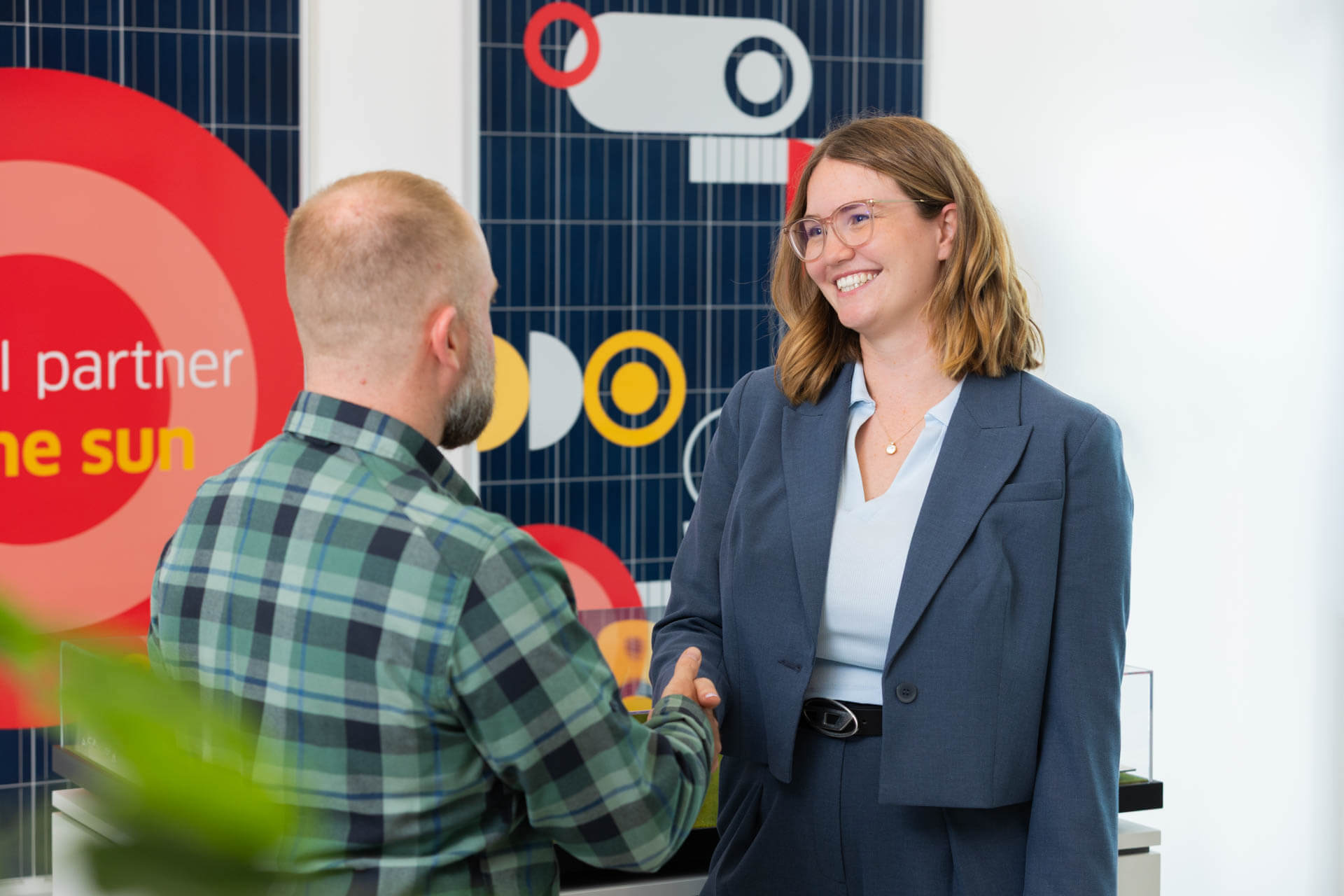 The picture shows two persons, a man and a woman shaking hands